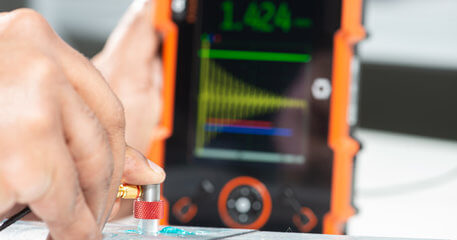 操作员使用Krautkrämer CL Go+超声波精密测厚仪检测金属样件,适用于航空航天、汽车等行业的无损检测需求。
