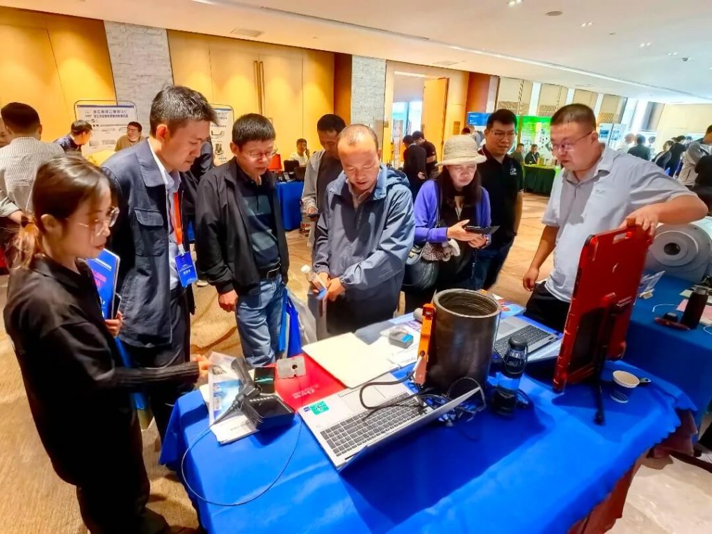 展会现场观众围观Waygate Technologies展台,技术人员讲解DXR Flex探测器的性能与应用,气氛互动积极。